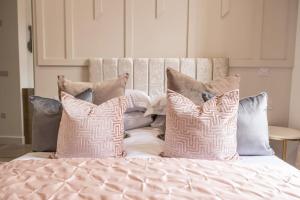 a bed with several pillows on top of it at The Pocklington - The Abbey Suite in Leicester