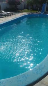 una piscina con acqua blu in un cortile di Pousada Monte Carlos a Galinhos