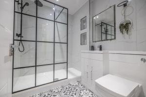 a white bathroom with a shower and a toilet at The Pocklington - The Abbey Suite in Leicester