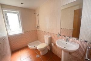 a bathroom with a toilet and a sink at BICOS ao MAR in Rianjo