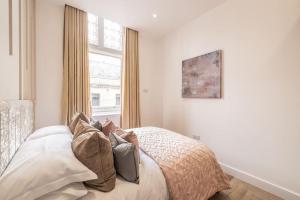 a bedroom with a bed with pillows and a window at The Pocklington - The Abbey Suite in Leicester