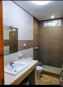 La salle de bains est pourvue d'un lavabo, de toilettes et d'un miroir. dans l'établissement Villa tofita, à Casablanca