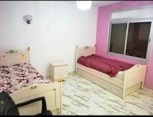 - une chambre avec 2 lits et une fenêtre dans l'établissement Villa tofita, à Casablanca