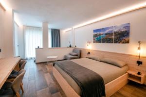 a hotel room with a large bed and a table at BORMIO N'JOY in Bormio