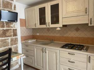 a kitchen with a sink and a stove and cabinets at La Casa Al Mare in Polignano a Mare