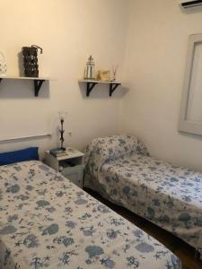 a bedroom with two beds and a table and shelves at La Casa Al Mare in Polignano a Mare