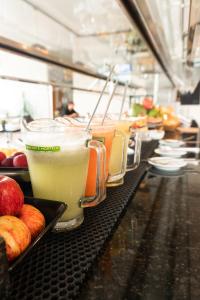 a row of glasses of drinks on a counter with apples at Raf Hotel in Umuarama +54 photos
