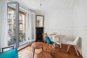 um quarto com uma mesa e cadeiras e uma janela em Elégant appartement parisien pour 2 personnes à Paris by Weekome em Paris