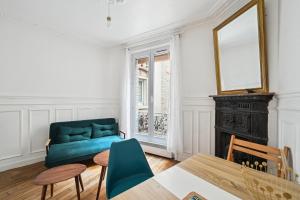 uma sala de estar com um sofá azul e uma mesa em Elégant appartement parisien pour 2 personnes à Paris by Weekome em Paris