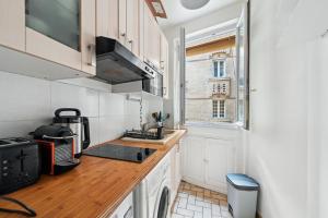 uma cozinha com um lavatório e um fogão forno superior em Elégant appartement parisien pour 2 personnes à Paris by Weekome em Paris