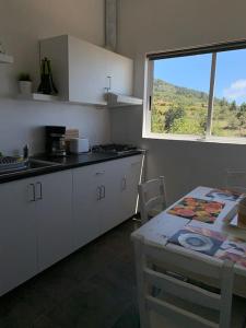 a kitchen with a table and a table and a window at TERRAZITA in Tijarafe