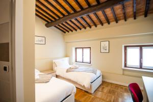 2 camas en una habitación con 2 ventanas en Residenza Villa Bella, en Mozzecane