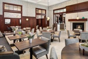 a restaurant with tables and chairs and a fireplace at Sheraton Duluth Hotel in Duluth