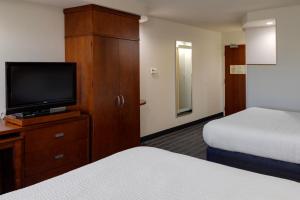 a hotel room with two beds and a flat screen tv at Courtyard by Marriott Oklahoma City North/Quail Springs in Oklahoma City