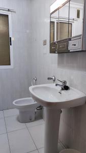 Baño blanco con lavabo y espejo en Gran piso en Ribadeo, en Ribadeo