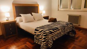 1 dormitorio con una manta de cebra en una cama en Gran piso en Ribadeo, en Ribadeo
