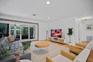 a living room with a couch and a tv at Enchanted Palms Villa in Boynton Beach