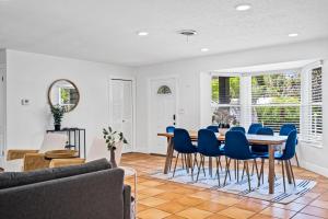 a dining room with a table and blue chairs at Enchanted Palms Villa in Boynton Beach