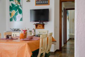 comedor con mesa y TV en Le Residenze di Baia Sant'Anna en Tanaunella