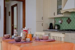 una cocina con una mesa con tazones. en Le Residenze di Baia Sant'Anna en Tanaunella