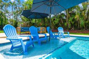 a group of chairs and an umbrella in a pool at Enchanted Palms Villa in Boynton Beach