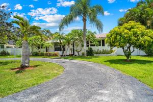 a driveway leading to a house with palm trees at Enchanted Palms Villa in Boynton Beach
