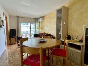 een woonkamer met een houten tafel en stoelen bij Rocamaura I D 1-2 in L'Estartit