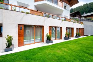 una vista exterior de una casa con césped verde en BORMIO N'JOY en Bormio