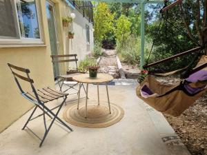 d'une terrasse couverte avec une table et deux chaises. dans l'établissement יחידת אירוח נעם, à Netiv HaLamed He