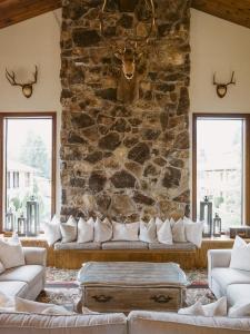 a living room with a stone wall with couches at Enzian Inn in Leavenworth