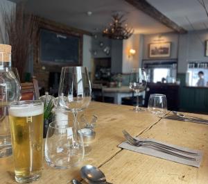 una mesa de madera con vasos de cerveza. en White Hart Hotel en Wiveliscombe