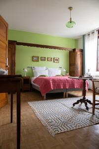 a bedroom with a bed with green walls and a table at Maison et table d'hôtes Le Camélia Blanc in Saint-Ciers-sur-Gironde