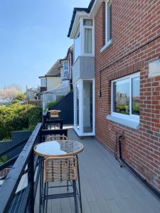 a patio with a table and chairs on a balcony at Clements House Swanage in Swanage