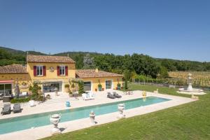 une villa avec une piscine en face d'une maison dans l'établissement Villa Florentina - 550m2, 5 Chambres - Golfe De Saint-Tropez, à Grimaud