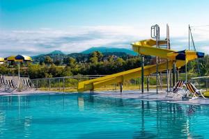 a swimming pool with a yellow slide in the water at Country House UNA in Cupra Marittima