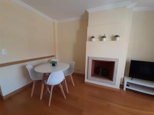 a living room with a table and chairs and a fireplace at Sesimbra TOP in Sesimbra