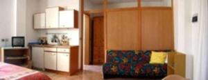 ein Wohnzimmer mit einem Sofa und einer Küche in der Unterkunft Poggio al Turco - Wohnung 2 in Casa Pallini