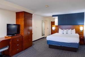a hotel room with a bed and a flat screen tv at Courtyard by Marriott Oklahoma City North/Quail Springs in The Village +70 photos