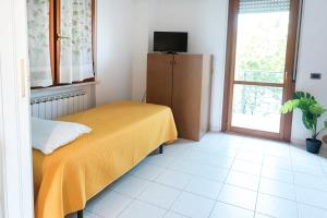 a bedroom with a bed and a television and a window at SE006 - Senigallia, bilocale sul mare con spiaggia in Senigallia