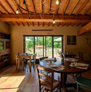 ein Esszimmer mit Tischen und Stühlen und einem großen Fenster in der Unterkunft Lo Smarrino agriturismo in Gubbio