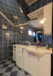 a bathroom with a sink and a tiled wall at Kuća za najam Villa Monika in Osijek