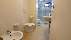 biała łazienka z toaletą i umywalką w obiekcie I Sapori Del Gargano w mieście Vieste