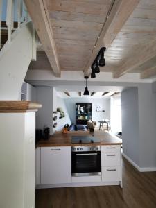 eine Küche mit weißen Schränken und einem schwarzen Backofen in der Unterkunft Homelig Ferienwohnung 1 Altstadt Sassnitz in Sassnitz