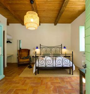 um quarto com uma cama, uma cadeira e um lustre em Lo Smarrino agriturismo em Gubbio