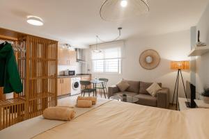 a bedroom with a large bed and a living room at Teatro Suites Málaga CITY FLAT in Málaga