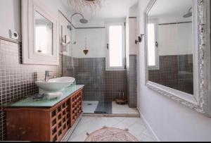 y baño con lavabo, espejo y ducha. en La casita de vanessa, en Playa del Hombre