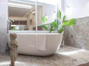 uma casa de banho com uma banheira com uma estátua em The Pocklington - The Ceremonial Suite em Leicester