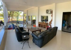 a living room with two leather couches and a table at Pousada solar do Cerrado in Rifaina