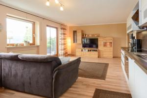 a living room with a couch and a kitchen at Ferienwohnung-Panoramablick-1 in Bodenmais