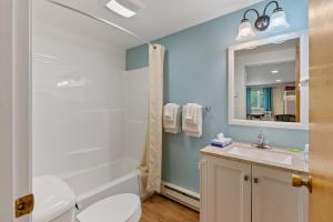 W łazience znajduje się toaleta, umywalka i lustro. w obiekcie Ne'r Beach Motel w mieście Wells